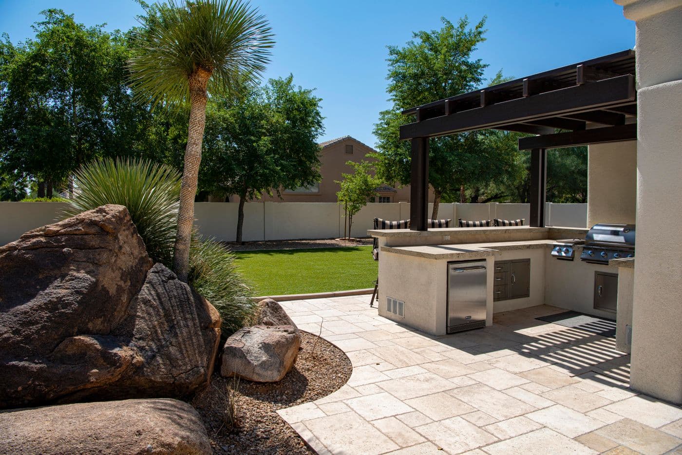 Paver patio with outdoor kitchen and lush landscaping